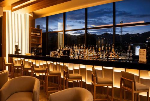 a bar with chairs and a view of a city at Wyndham Bogota in Bogotá