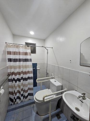 a bathroom with a toilet and a sink at Kasa Boutique Residence in Cebu City