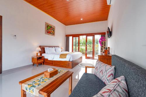 a bedroom with a bed and a living room with a couch at The Siantar Luxury Villa And Spa in Nusa Penida