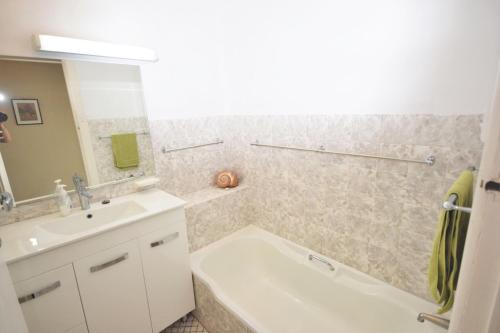 a bathroom with a white tub and a sink and a bath tub at The Outlook in Nambucca Heads