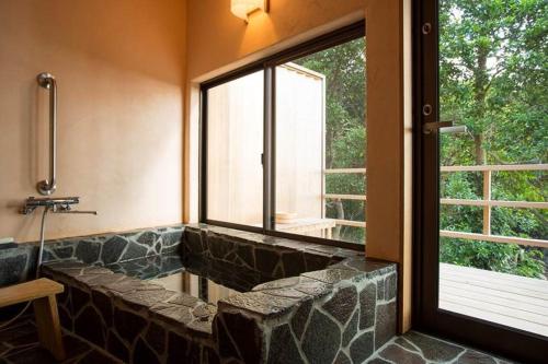 a bathroom with a stone bench next to a window at Cottage Views in Yakushima