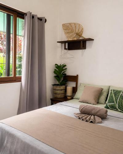 a bedroom with a large bed with a window at Pascoe's Units Siargao- Suites in General Luna