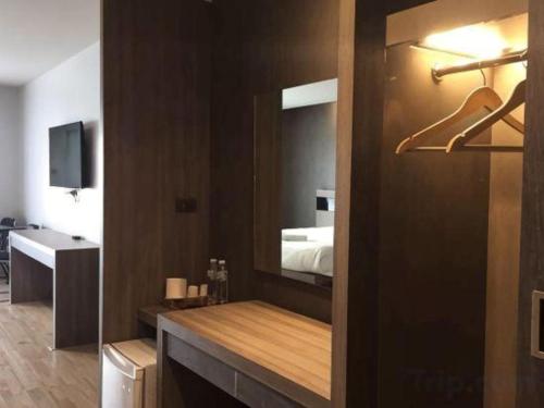 a bathroom with a large mirror and a bed at Melodi Hotel Dannok in Sadao