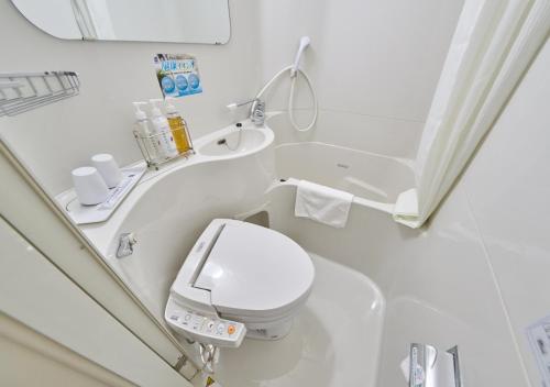 a white bathroom with a toilet and a sink at Super Hotel Shinyokohama in Yokohama