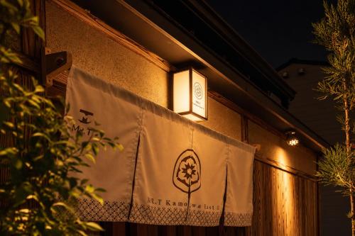 a flag hanging on the side of a building at MR T Kamogawa East 12 in Kyoto