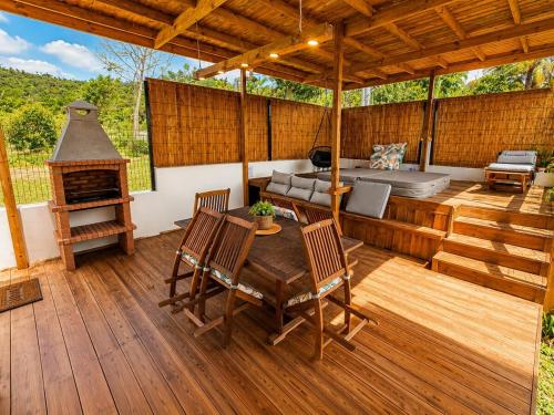 a patio with a table and a bed and a fireplace at L'Eden du Piton des Roches in La Plaine des Palmistes