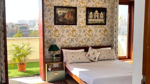 a bedroom with a bed and a window at Flora A suite in Jaipur