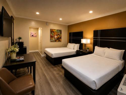 a hotel room with two beds and a chair at The Boards AC in Atlantic City