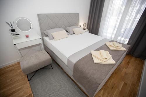 a bedroom with a bed with a mirror and a chair at Apartman Solis in Trebinje