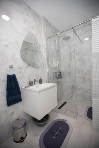 a bathroom with a white sink and a shower at Apartman Solis in Trebinje