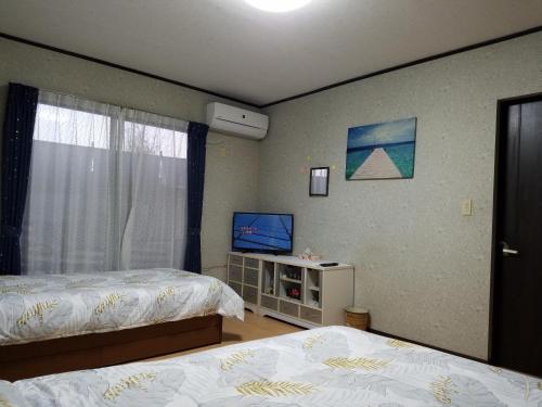 a bedroom with two beds and a flat screen tv at Bibi Vacation Rental Only 2 groups per day Vacation STAY 1284 in Sakai