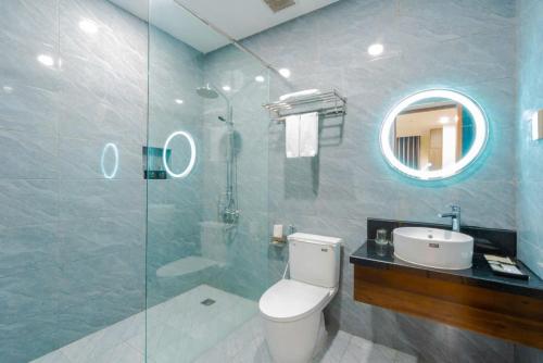 a bathroom with a toilet and a sink and a mirror at Happy Life Hotel District 7 Gần SECC in Ho Chi Minh City