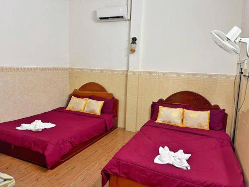 two beds in a room with purple sheets at Unique Hotel in Phnom Penh