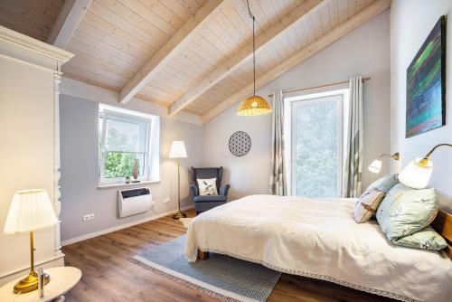 a bedroom with a large bed and two windows at Blaues Haus in Buchloe