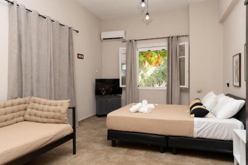 a bedroom with two beds and a couch and a television at Mani Spot Casa Elia in Areopoli