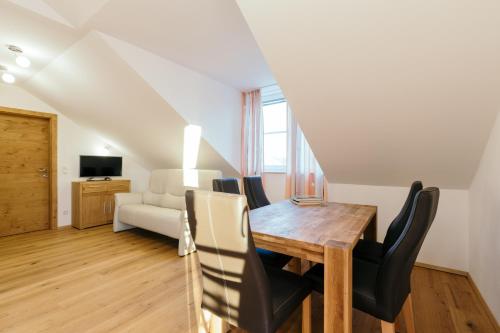 a dining room with a table and chairs and a couch at Ferienwohnung Mayrhofer in Hofkirchen im Mühlkreise