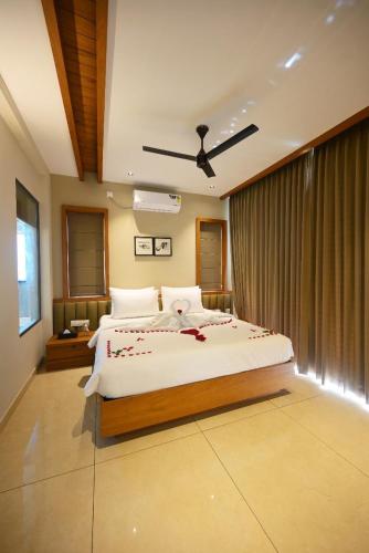 a bedroom with a large bed with red flowers on it at Leal Resort-Wayanad in Meppādi