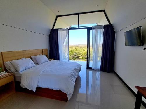a bedroom with a bed and a large window at Payas Private Farm Villa in Praya