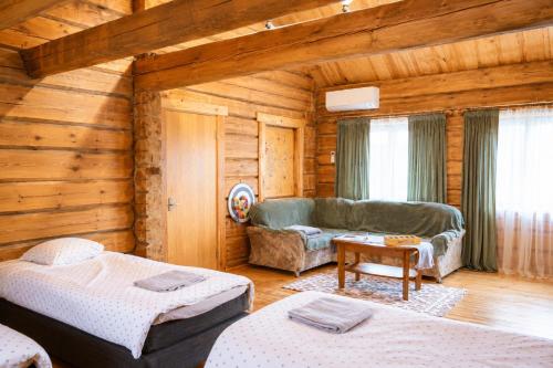 a log room with two beds and a couch at Privaatne maja metsas, kraanist voolab allikavesi in Plaani