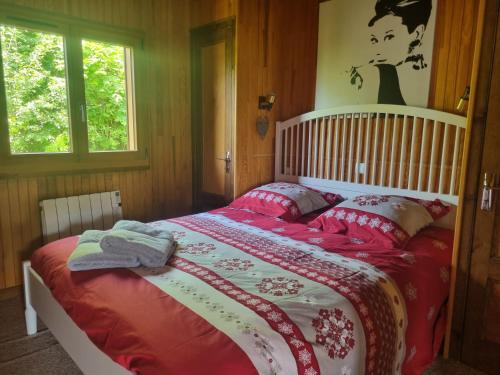 a bedroom with a bed with a red and white comforter at Comfortable Chalet with spectacular mountain views in Verchaix