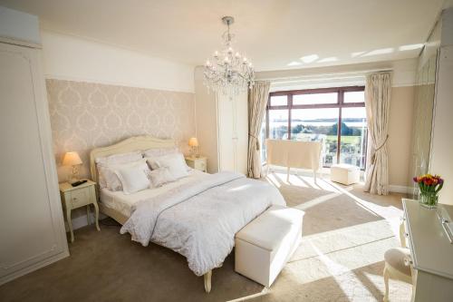 a bedroom with a white bed and a chandelier at 29 Marine Crescent in Waterloo