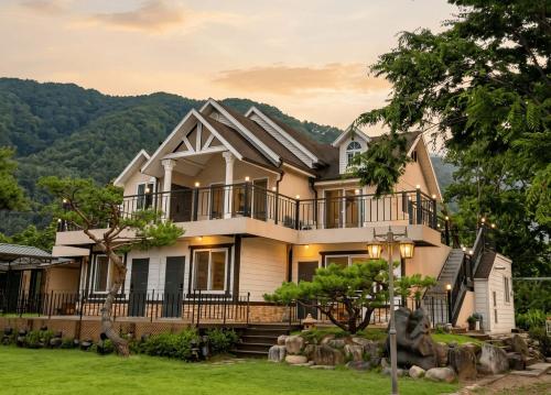 a house with a mountain in the background at Gapyeong Yunseul Pension in Chuktul-li