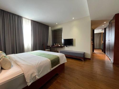 a hotel room with a bed and a television at CLOVER HOTEL MONIVONG By LEE in Phnom Penh