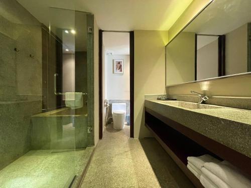 a bathroom with a glass shower and a toilet at CLOVER HOTEL MONIVONG By LEE in Phnom Penh