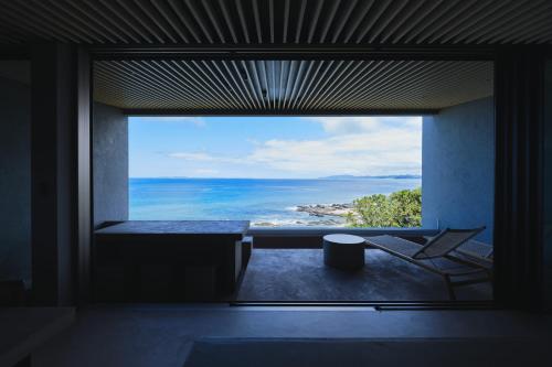 a window in a room with a view of the ocean at THE THIRD PLACE tatéyama 楼 in Tateyama