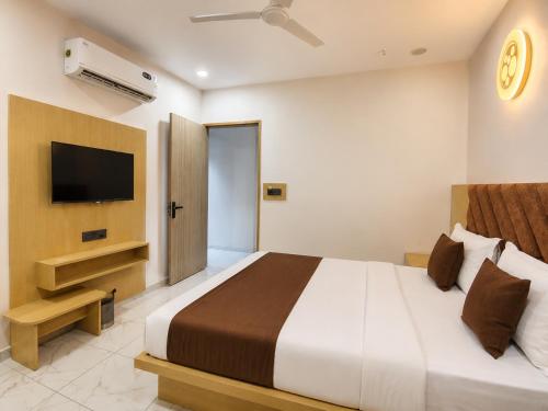 a bedroom with a large bed and a television at Hotel Elite in Ahmedabad
