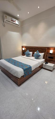 a bedroom with a large bed with blue pillows at Emerald Nest in Pandharpur