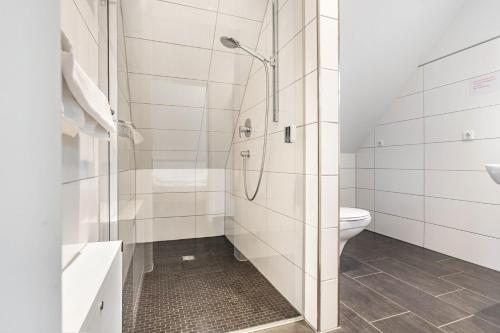 a white bathroom with a shower and a toilet at Haus 50 in Röbel
