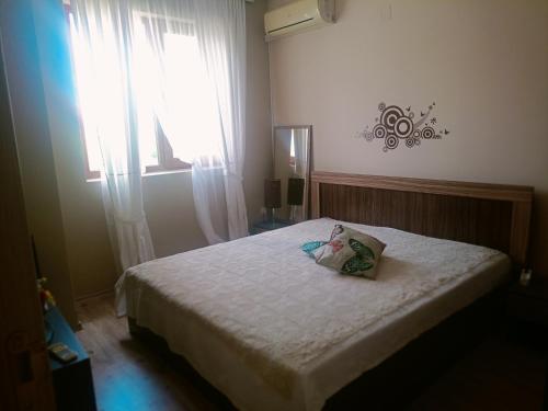 a bedroom with a bed with a pillow on it at Къща Уют in Rogachevo