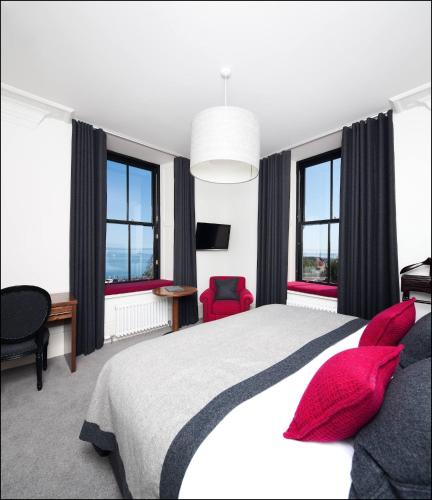 a bedroom with a large bed with red pillows at The Douglas Hotel in Brodick