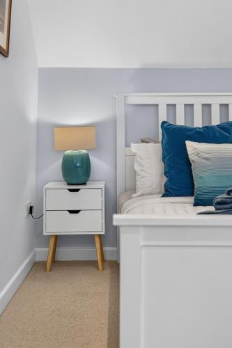 a bedroom with a bed with a white nightstand and a blue pillow at Conners in Gardenstown