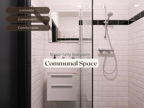 a white bathroom with a shower and a commuclearspace sign at Cozy Room w Shared Kitchen, Fast WiFi Near Station in Tilburg