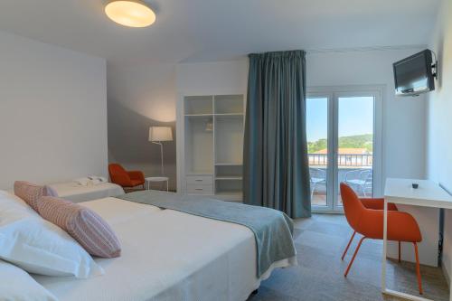 a hotel room with a bed and a balcony at Hotel Ton in Sanxenxo