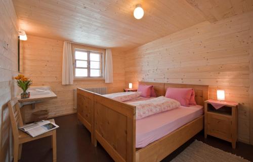 a bedroom with a bed in a wooden cabin at Hotel Restaurant Capricorns in Wergenstein