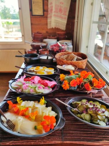 a table with many plates of food on it at Majatalo Puukarin Pysäkki in Nurmes