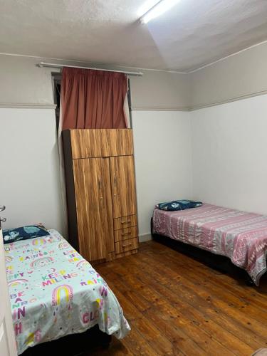 a room with two beds and a window in it at Willow whispers in Gqeberha