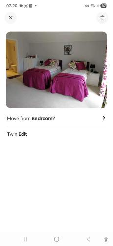 two beds in a room with purple sheets at Spacious Luxury Room in Brixham