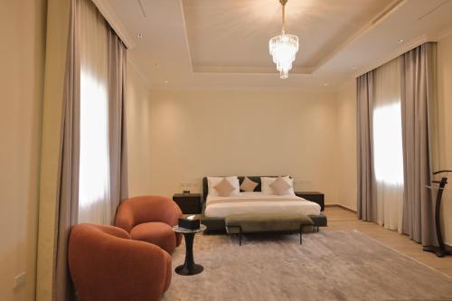 a bedroom with a bed and two chairs and a chandelier at Jimma Palace Hotel in Jīma