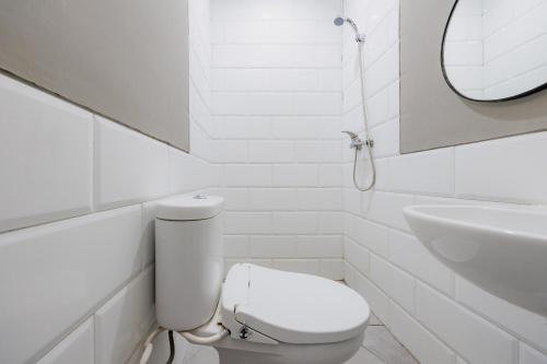 a white bathroom with a toilet and a sink at RedDoorz near Mangga Dua Mall in Jakarta