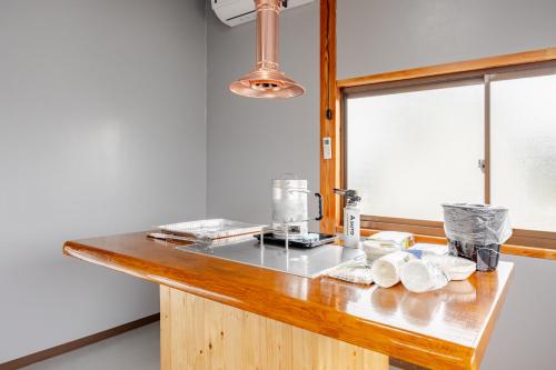 a kitchen with a counter with a mixer and a window at ジャポニークハウス in Sanmu