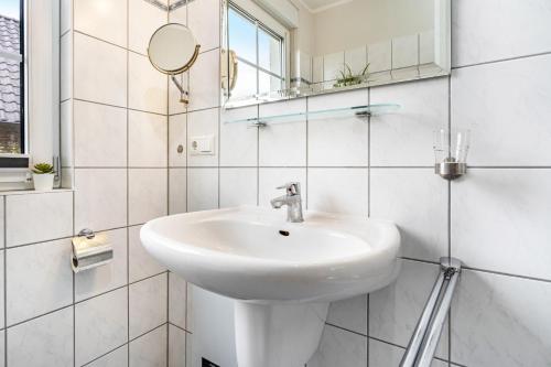 a white bathroom with a sink and a mirror at Haus 7 in Röbel