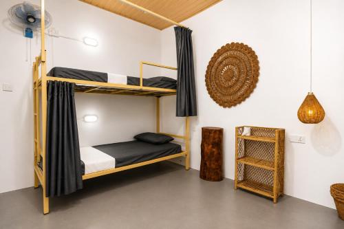 a bedroom with bunk beds in a room at Fins Arugambay in Arugam Bay