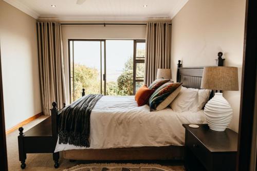 a bedroom with a bed and a large window at 2 Zebra View, Cathkin Estate in Winterton