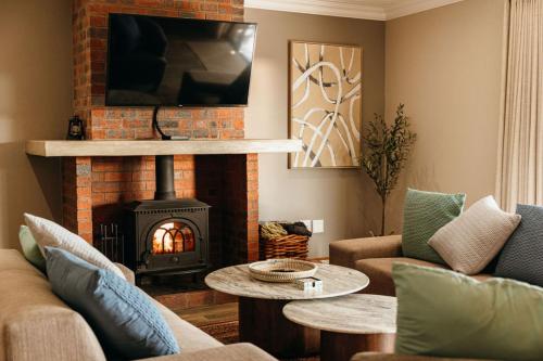 a living room with a brick fireplace with a fire place at 2 Zebra View, Cathkin Estate in Winterton