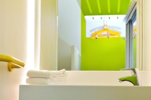 La salle de bains est pourvue d'un lavabo, d'un miroir et de serviettes. dans l'établissement hotelF1 Tours Nord, à Tours