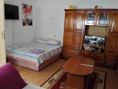 a bedroom with a bed and a wooden cabinet at Apartmani Dević Šušanj in Bar